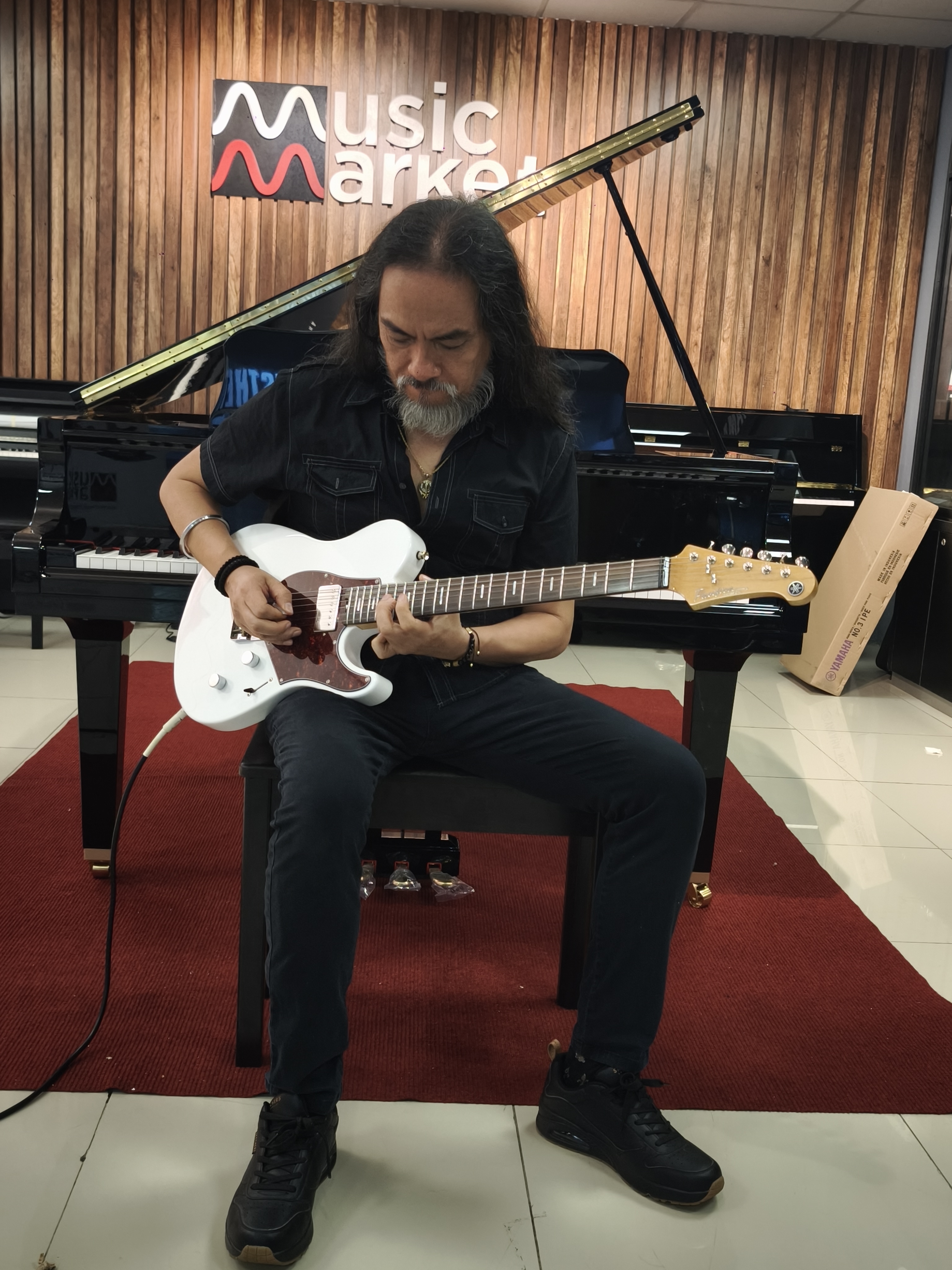 Kike Yompian tocando una guitarra Yamaha en Music Market