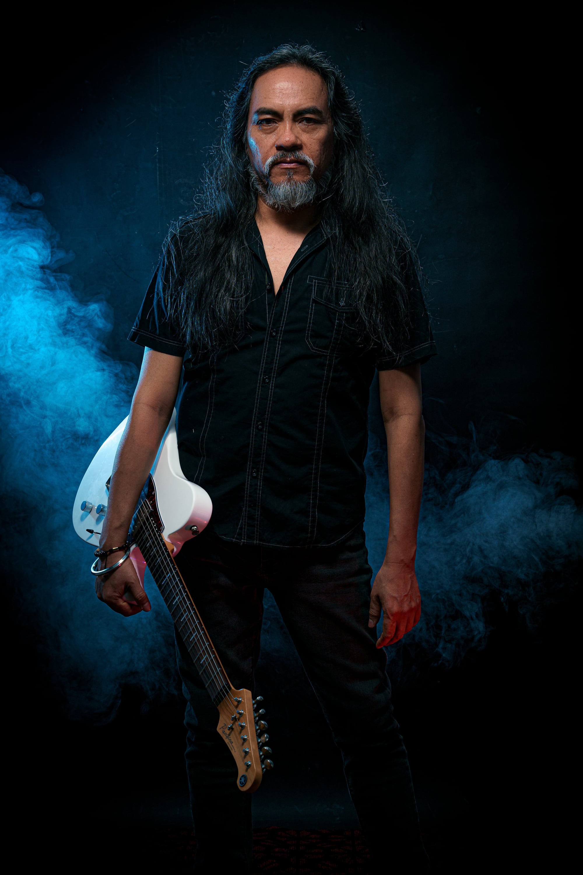 Retrato reciente de Kike Yompian con guitarra y una atmósfera de humo azul