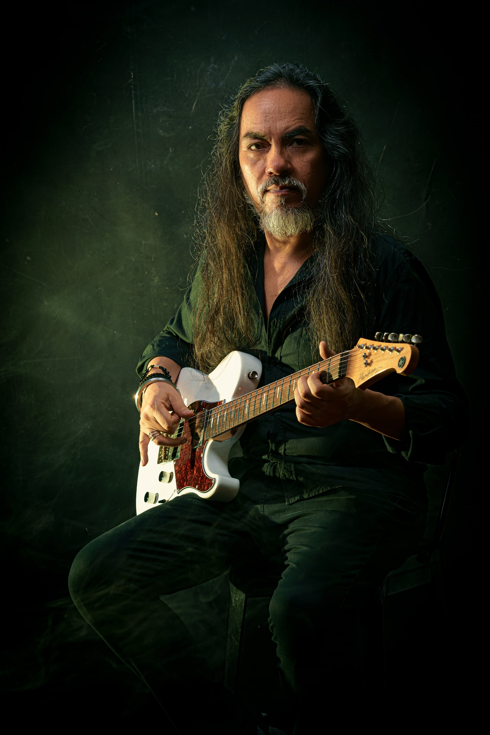 Retrato reciente de Kike Yompian sentado con su guitarra eléctrica